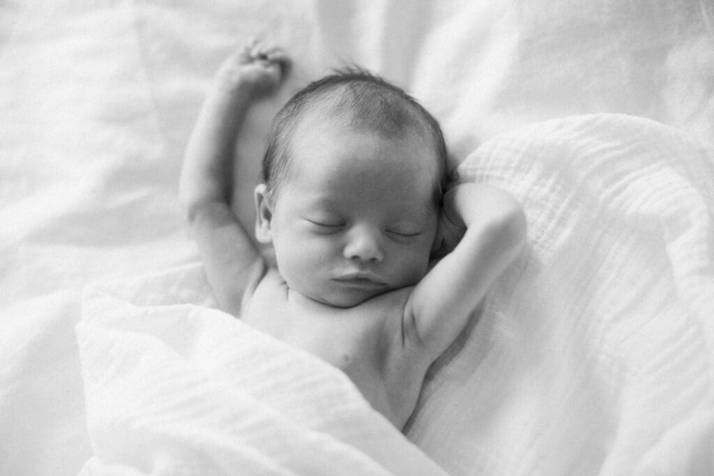 back and white photo of a newborn baby waking up