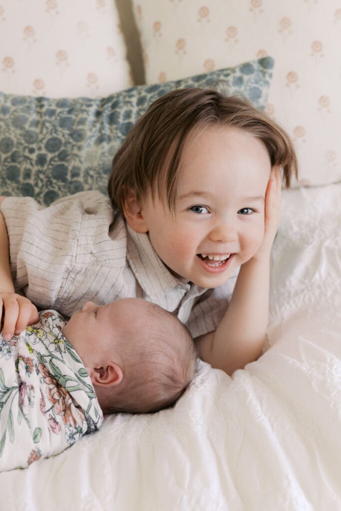 brother smiling with new born baby sister